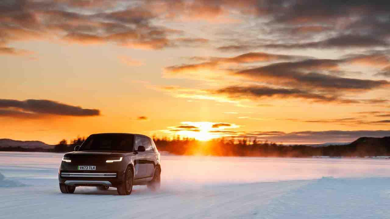 Range Rover Electric - Front- und Seitenansicht im Schnee mit Sonnenuntergang